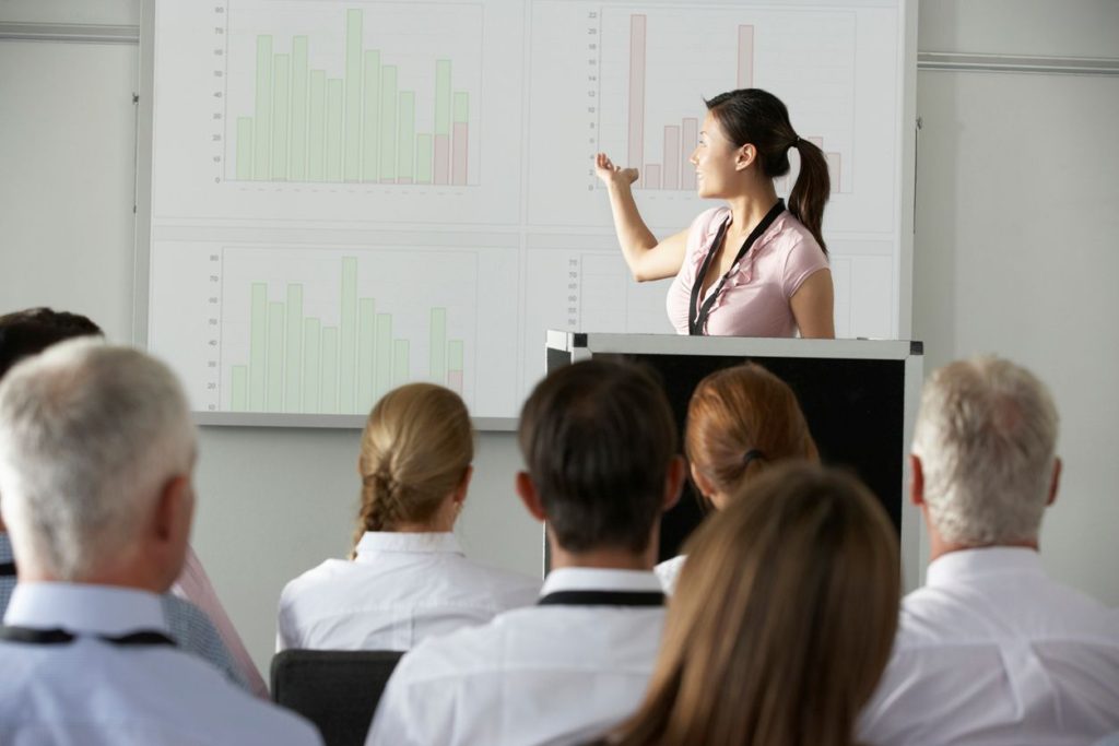 Woman presenting bar graph to colleagues