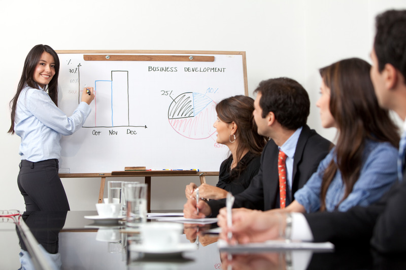 Woman presenting graphs to colleagues in business meeting